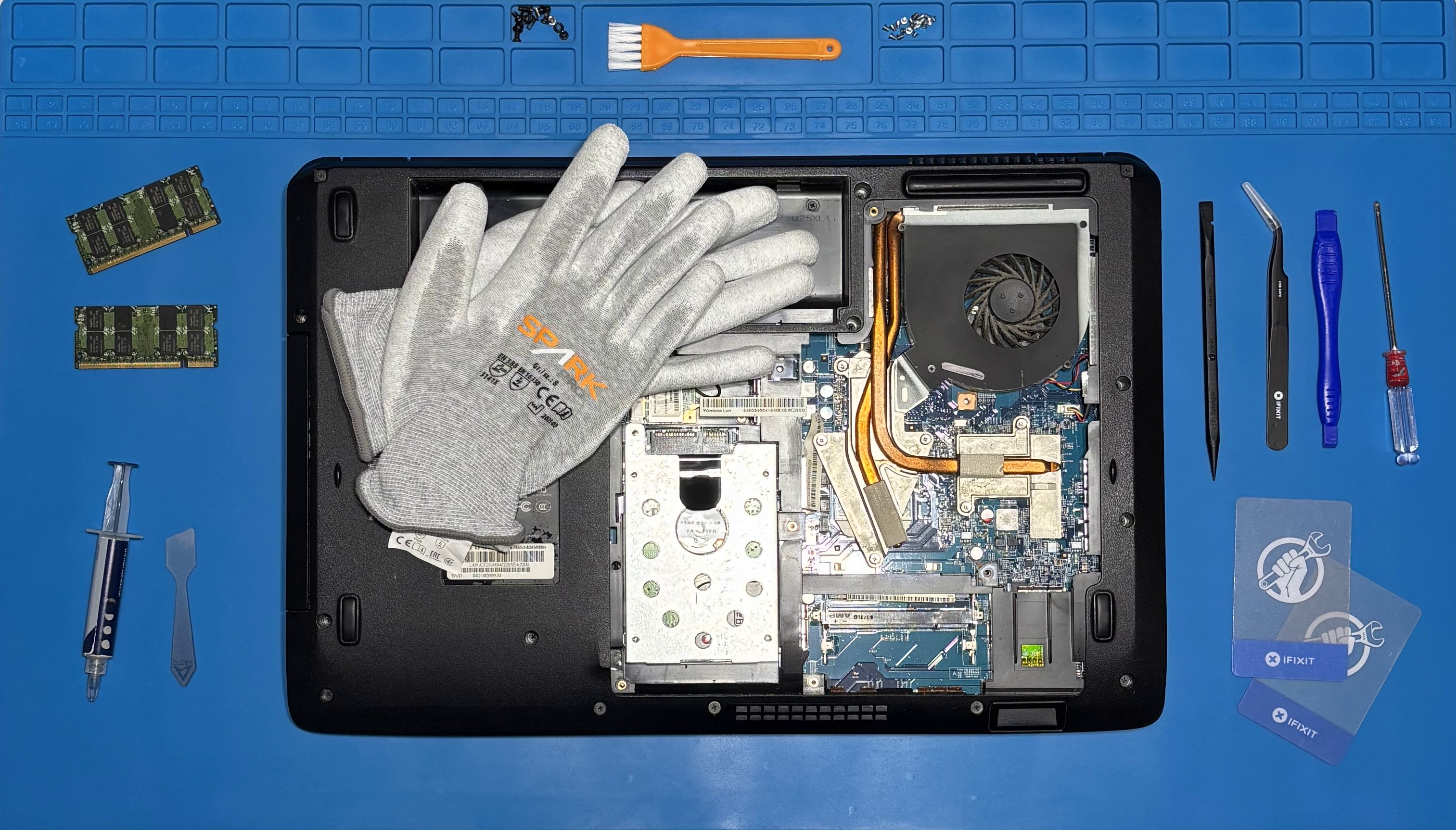 Geöffneter Laptop auf Arbeitsmatte mit Werkzeugen